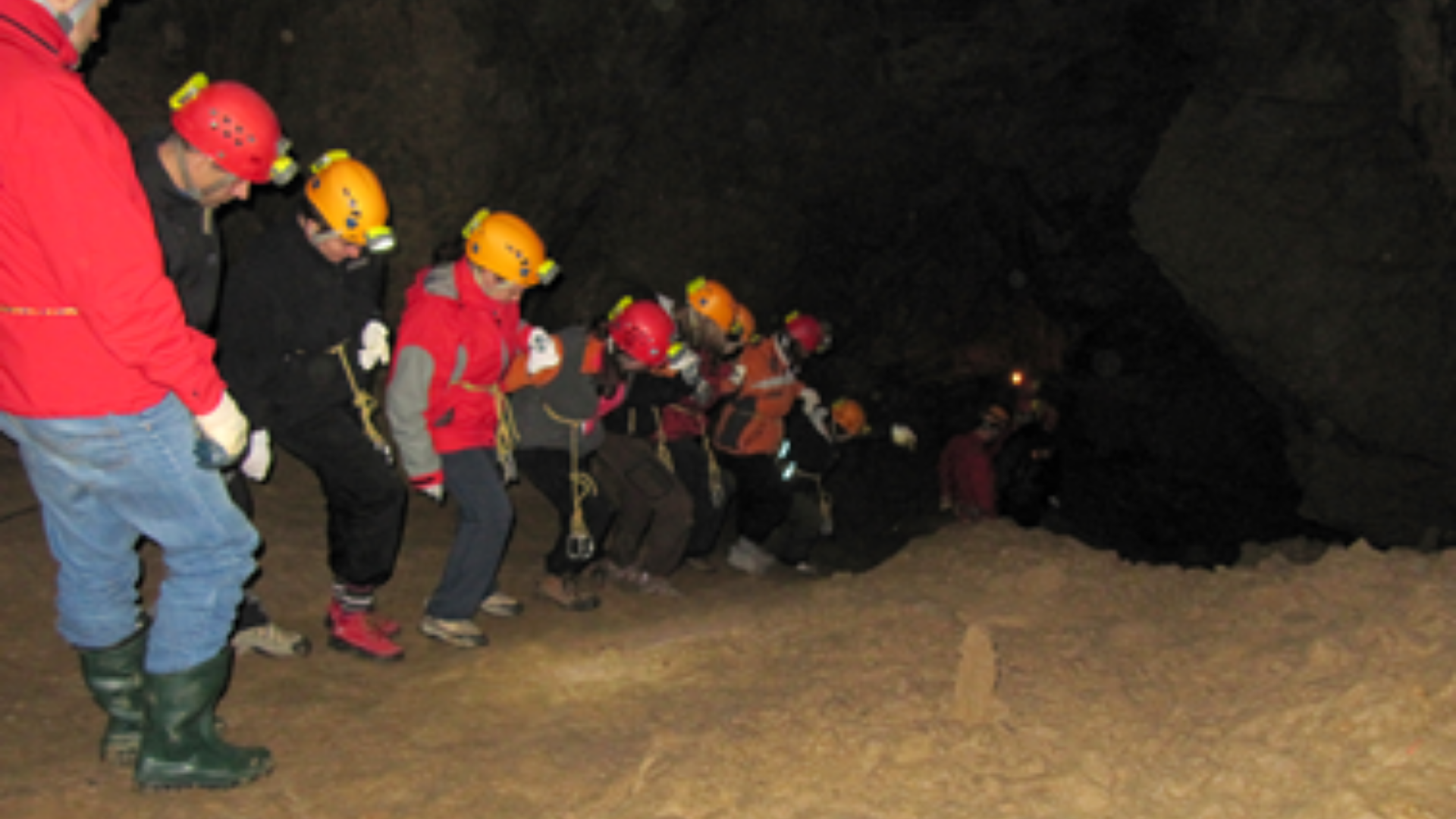 Udeleženci se spuščajo v jamo