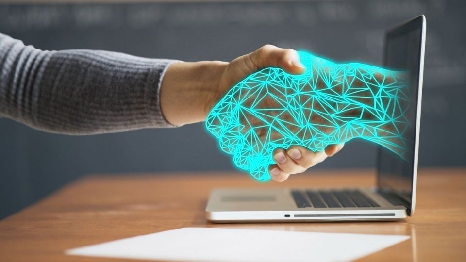 Man shaking hands with hand coming out of a computer screen