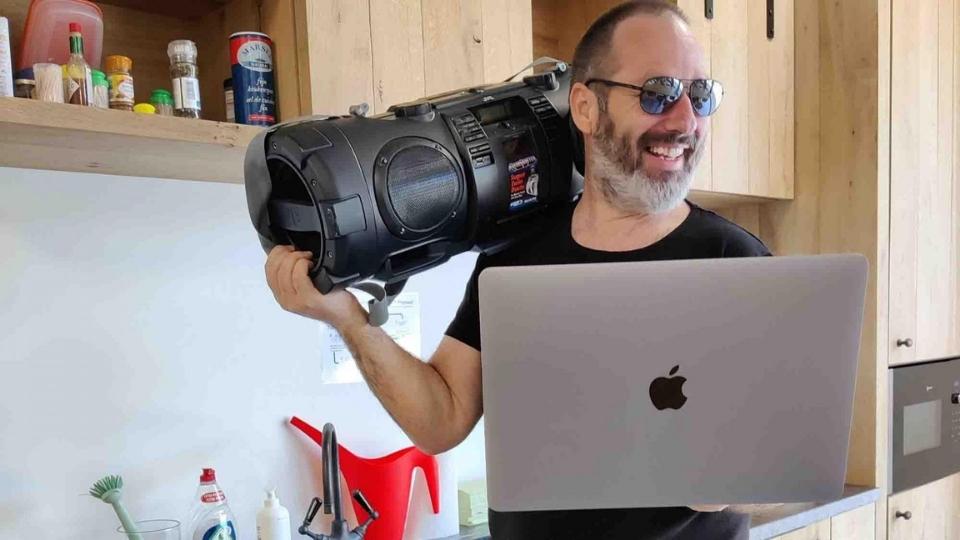 team building participant playing music on boombox and laughing