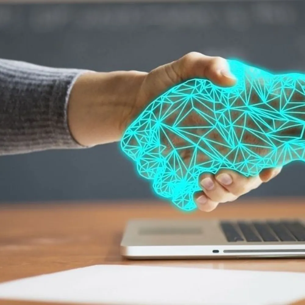 Man shaking hands with hand coming out of a computer screen