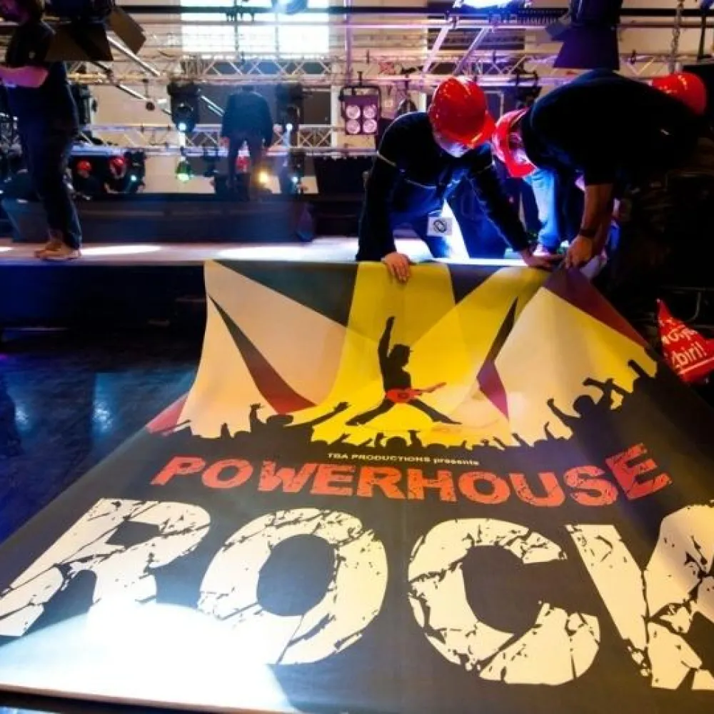 Teambuilding participants hanging up a Powerhouse rock banner